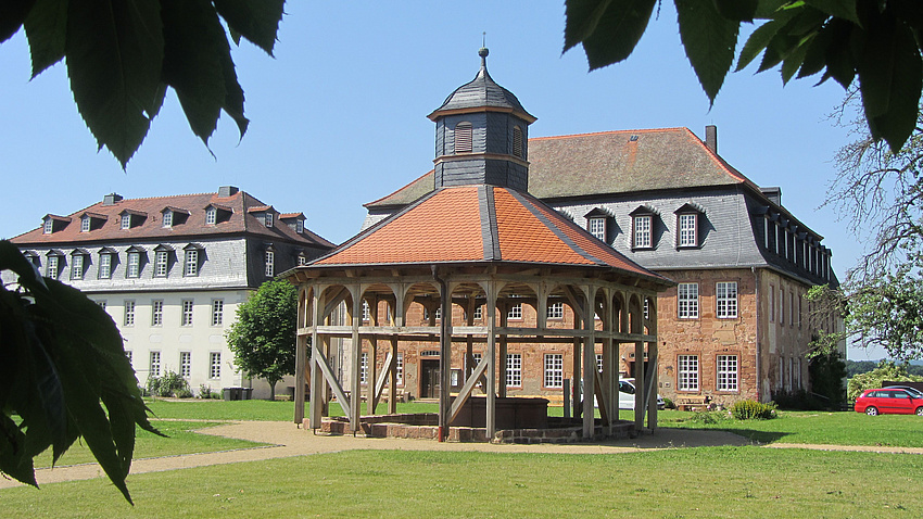 zwei Herrenhäuser sowie eine offene Kapelle aus Holz mit Turm