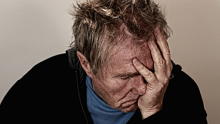 Verzweifelter Mann hält Kopf in seiner Hand, Foto Gert Altmann auf Pixabay