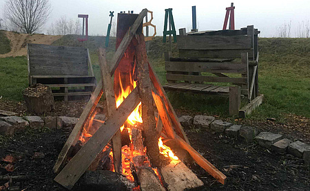 Aufgestelltes Holz zu einem Lagerfeuer, Flamen darin