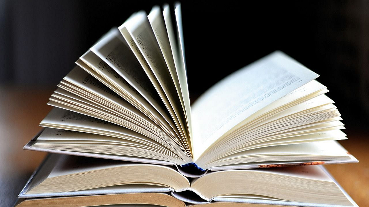 Drei aufeinanderliegende, aufgeschlagene Bücher