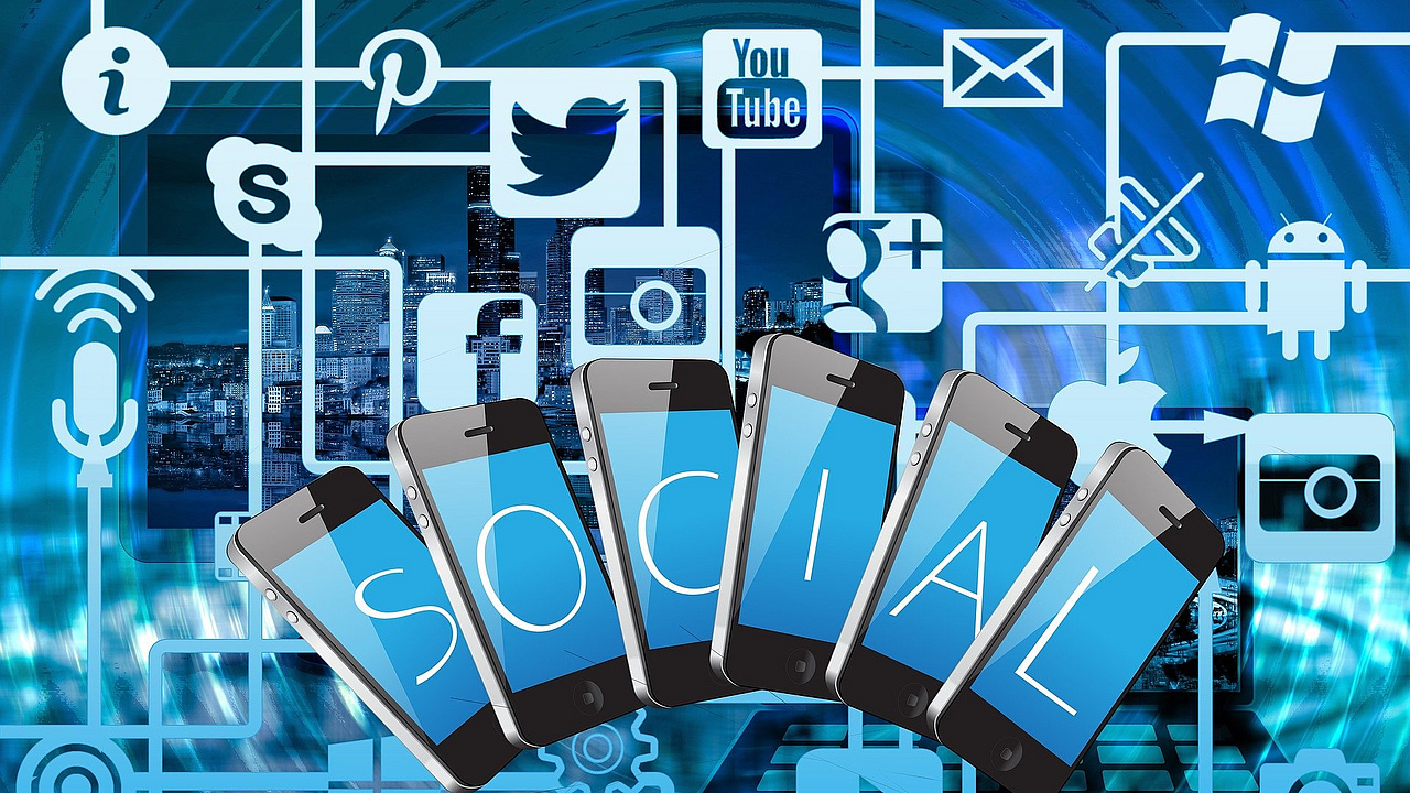 Eine Collage in Blautönen gehalten zeigt im Hintergrund eine Großstadt. Davor sind Handys und verschiedene Symbole der sozialen Medien aufgezeigt, die miteinander vernetzt sind.