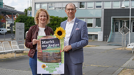 Gemeinsames Foto von Landrat und Erster Kreisbeigeordneter mit einem Plakat zum Markt der Region.