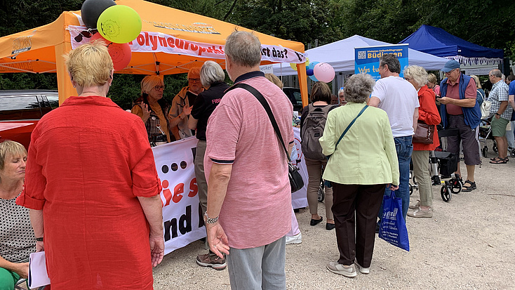 An verschiedenen Ständen auf der Kiespromenade befinden sich viele interessierte Besuch im Gespräch