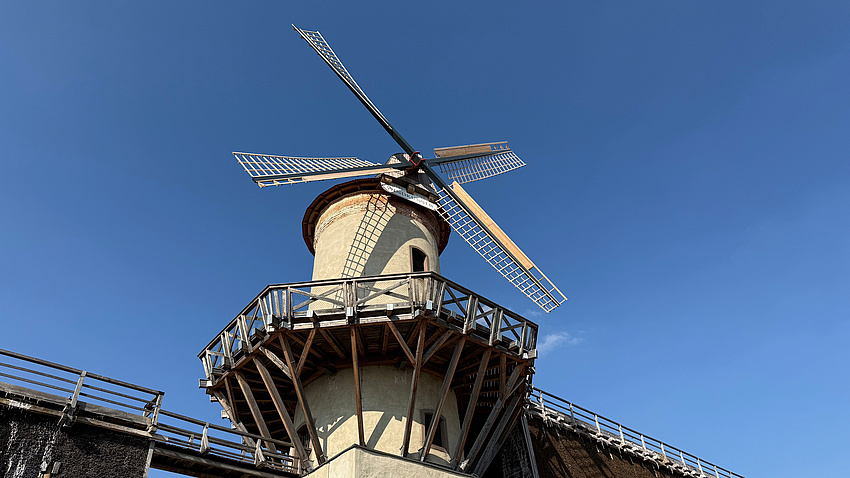 Eine Windmühle vor blauem Himmel.