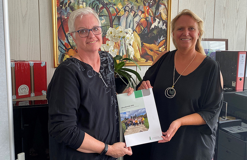 Die beiden Frauen halten den Bildungsbericht hoch.