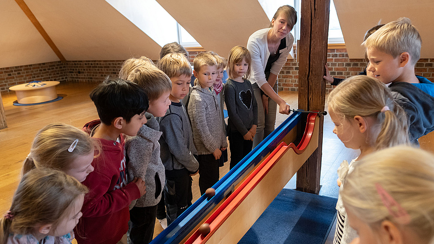 Kinder, die an einer Murmelbahn spielen