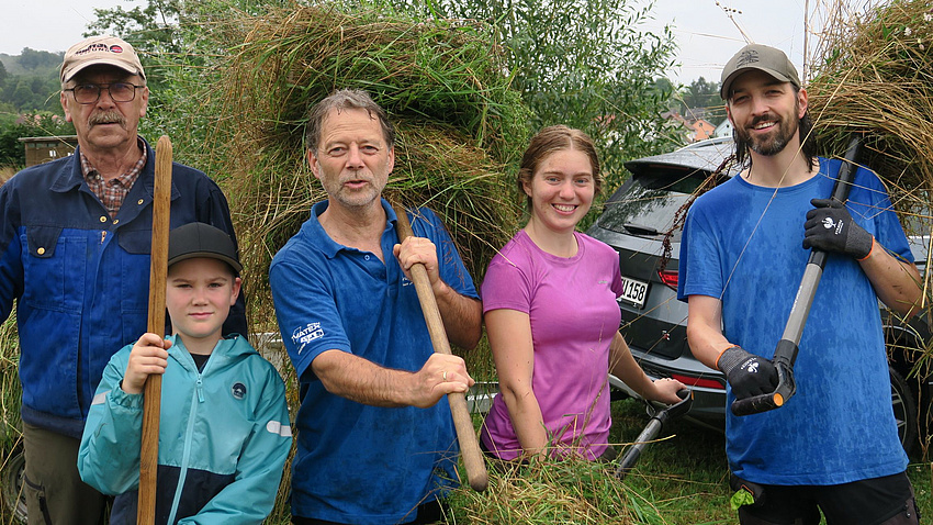 Dietmar Wäß mit zwei Erwachsen und zwei Kindern beim Heu holen