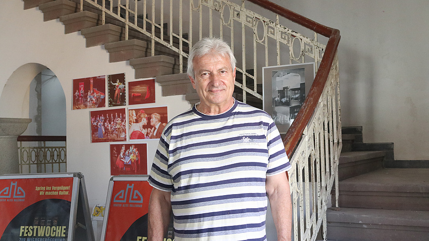 Ein Mann steht in einem Treppenhaus eines alten Gebäudes.