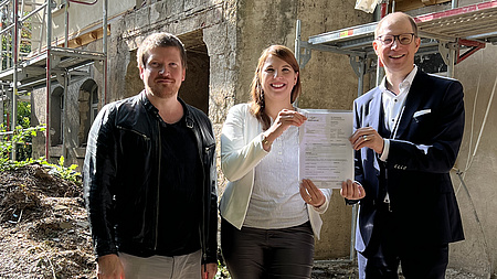 Landrat Jan Weckler übergibt dem Ehepaar Stevens den Bescheid.