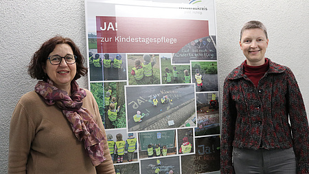 Kreisbeigeordnete Marion Götz und Fachstellenleiterin Familienförderung Andrea Rosenberger vor einem Plakat mit der Aufschrift: "Ja zur Kindertagespflege!"