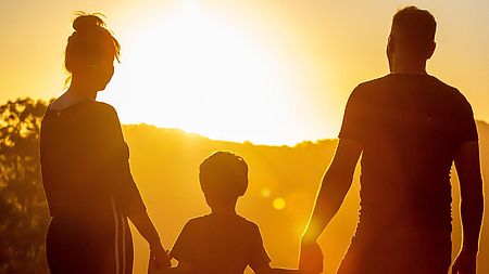 Eine Familie vor einem Sonnenuntergang.