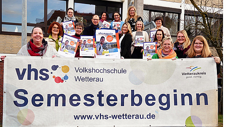 Die Kursleiterinnnen halten eine Plakat hoch.