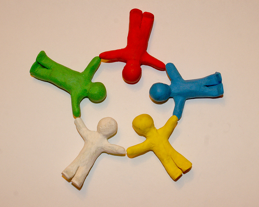 4 Knet-Menschen liegen auf dem Boden und halten sich an den Händen, bilden somit einen Kreis, Bildquelle S.Hofschläger/Pixelio.de