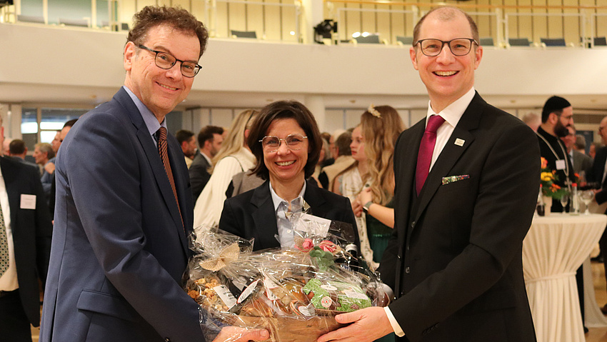 Kreistagsvorsitzender Armin Häuser, Ille-Geschäftsführerin Marion Gottschalk und Landrat Jan Weckler präsentieren einen Geschenkkorb.