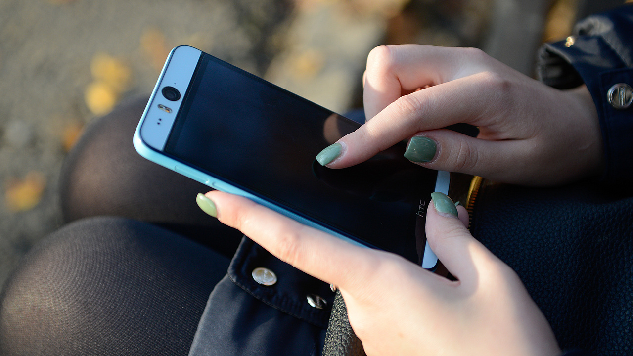 Hand eines Mädchens mit Smartphone