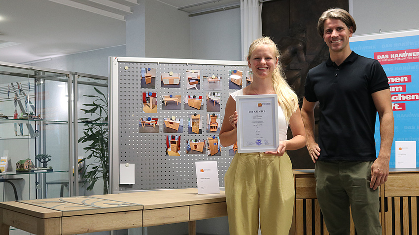 Zwei Menschen stehen vor einem Schreibtisch.