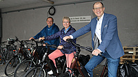 Fuhrparkleiter Thomas Sieber, Fachstellenleiterin Marion Posch und Landrat Jan Weckler sitzen auf E-Bikes.