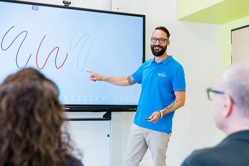 Referent steht an Interaktiver Schultafel