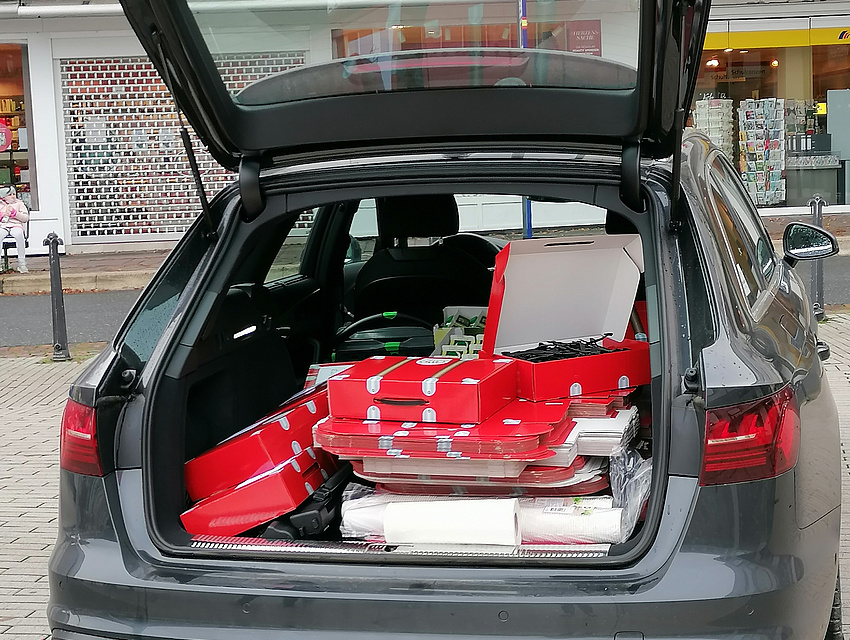 Rote Faltköfferchen werden aus dem Kofferraum geladen