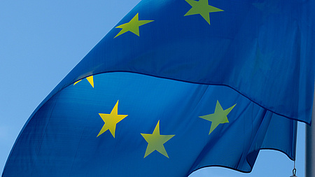 Die europäische Flagge vor blauem Himmel.