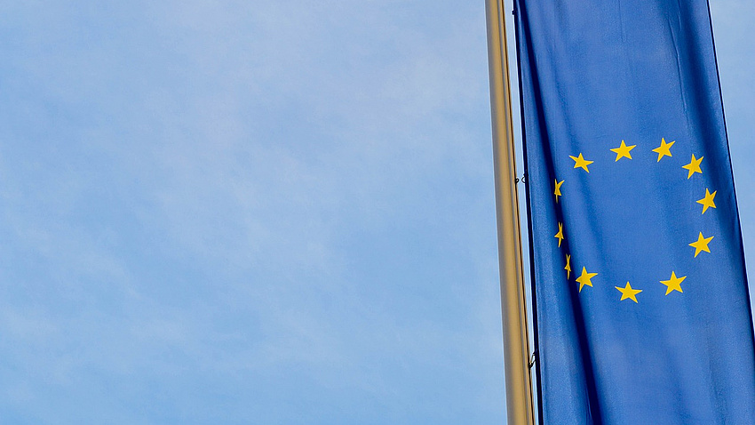 Die europäische Flagge vor blauem Himmel.