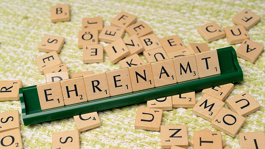 Aus Scrabble-Buchstaben wurde das Wort Ehrenamt gelegt.