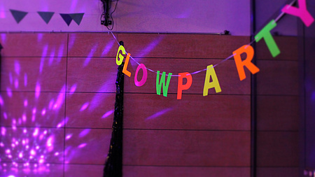 Eine Girlande mit dem Schriftzug Glowparty leuchtet