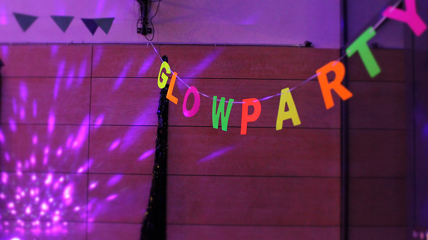 Eine Girlande mit dem Schriftzug Glowparty leuchtet