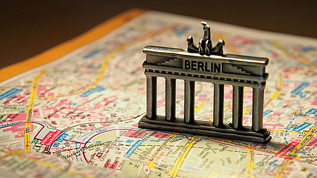 Auf einem Stadtplan von Berlin steht eine Miniatur der Brandenburger Tors.