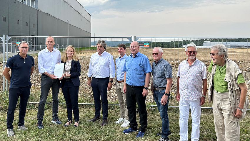 Eine Gruppe von Menschen steht auf einem Acker.