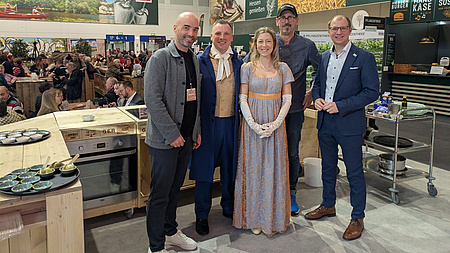 Lars-Henning Metz, Matthias Kallmayer, Ena Kaufmann, Reiner Neidhart und Landrat Jan Weckler vor einem Messestand.