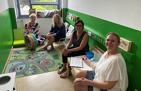 Drei Frauen sitzen in einem Raum und haben Spielzeuge in der Hand.