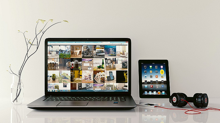 Ein Laptop und ein Tablet auf einem Tisch.