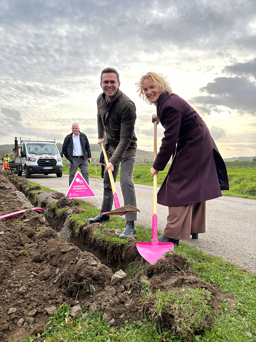 Zwei Menschen mit pinken Schippen in der Hand