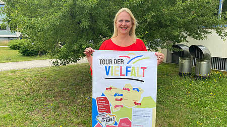Erste Kreisbeigeordnete und Sozialdezernentin Stephanie Becker-Bösch mit einem Plakat zur Tour der Vielfalt