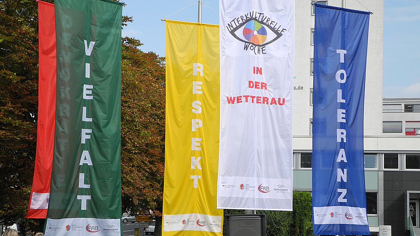 Flaggen an einem Fahnenmast. Auf jeder der Flaggen steht eines der Worte: Demokratie, Vielfalt, Respekt, Toleranz