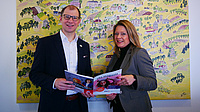 Landrat Jan Weckler und vhs-Leiterin Ann-Karin Schild halten das vhs-Magazin in der Hand.