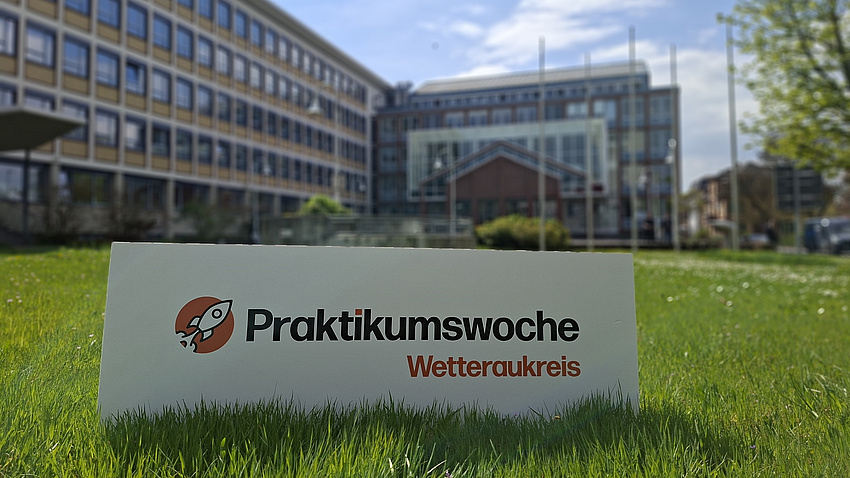 Ein Schild steht auf einer Wiese mit der Aufschrift Praktikumswoche Wetteraukreis