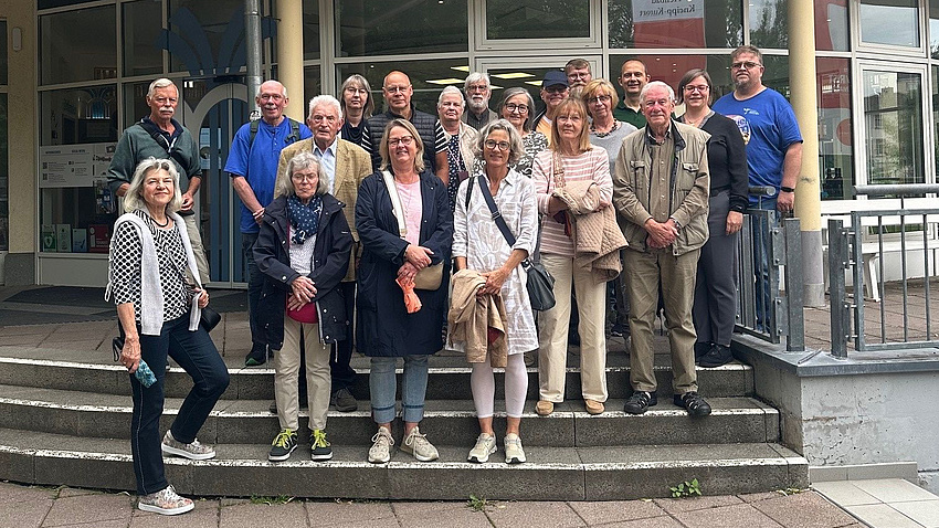 Eine Gruppe Menschen steht auf einer Treppe im Freien.