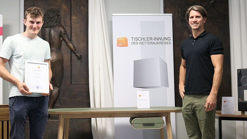 Zwei Menschen stehen vor einem Schreibtisch.