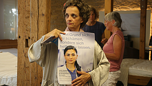 Eine Frau hält ein Plakat hoch. 