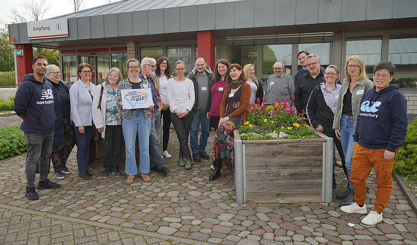 Eine Gruppe von Menschen steht vor dem Gebäude des bbw.
