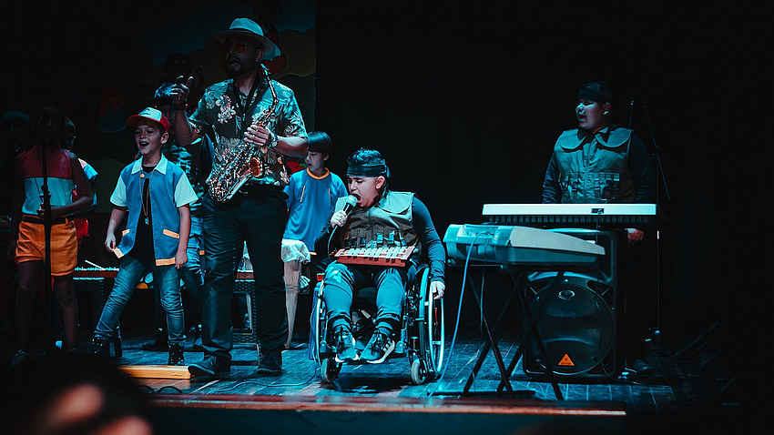 Band mit Kindern, darunter eins im Rollstuhl