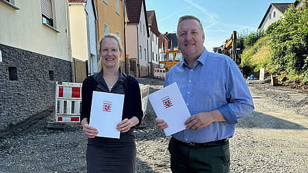 Zwei Menschen stehen auf einer Straße, die gerade neu gebaut wird.