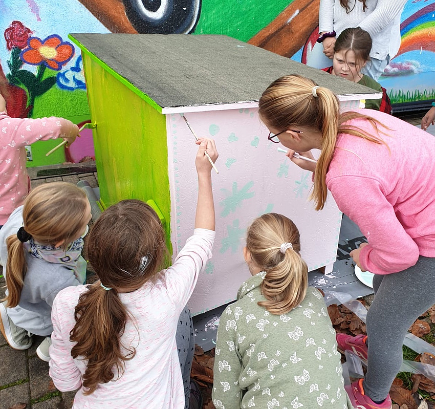 Mädchen bauen einen Hundehütte bei den Mädchenaktionstagen 2019 viele Mädchen sitzen um eine Hundehütte und bemalen sie