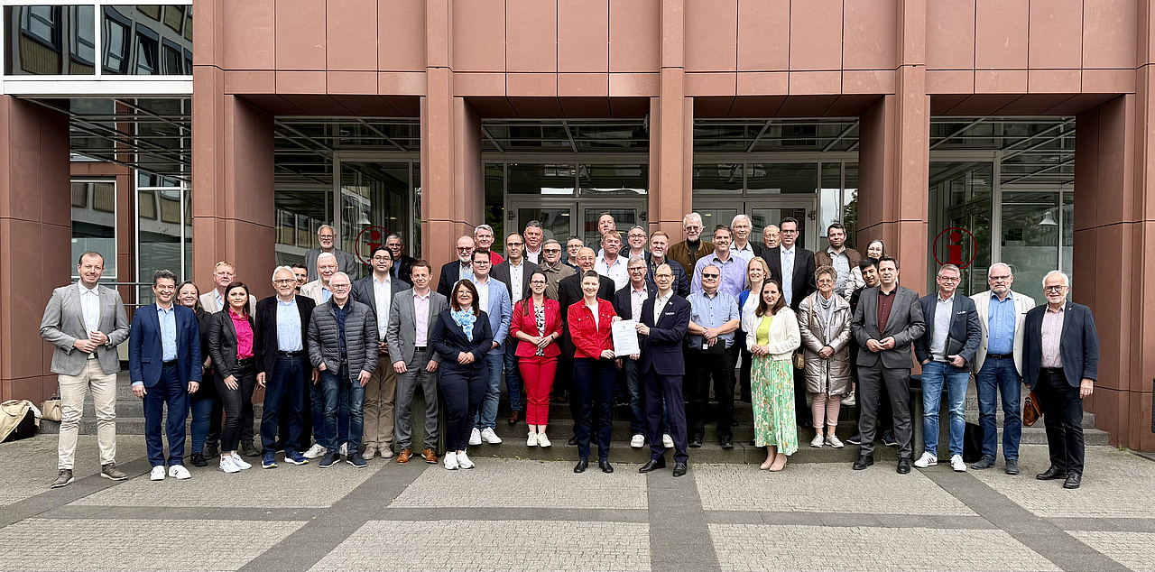 Viele Personen vor einem Gebäude zum Gruppenfoto aufgestellt