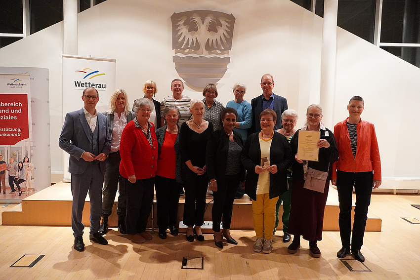 Eine Gruppe von Leuten. Sie lächeln in die Kamera.
