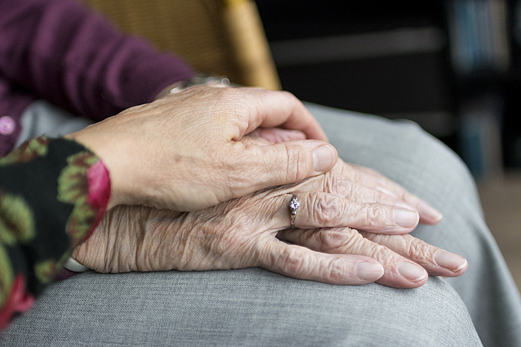 Eine Hand liegt auf der Hand eines älteren Menschen. Bild von Sabine van Erp auf Pixabay