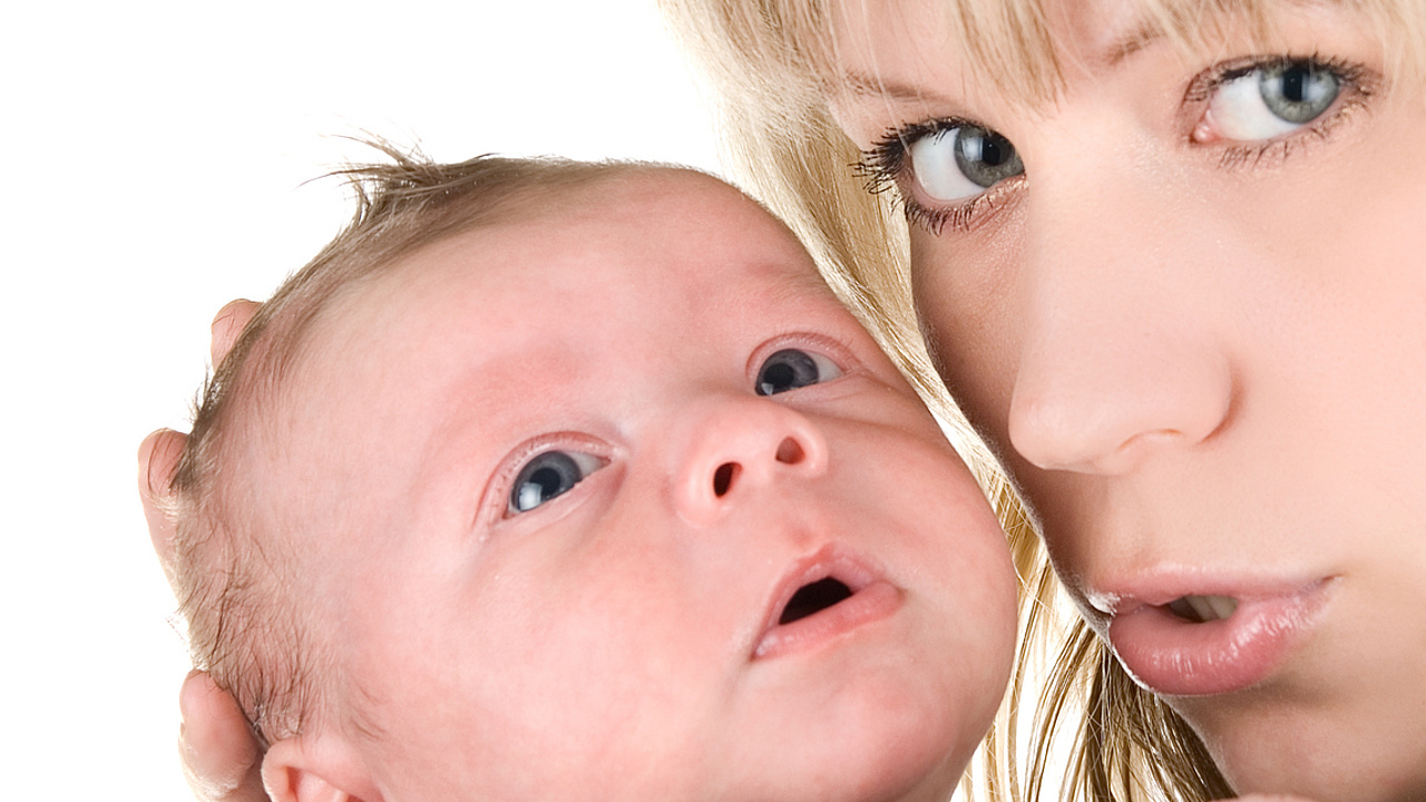 Gesichter einer Mutter und eines Neugeborenen