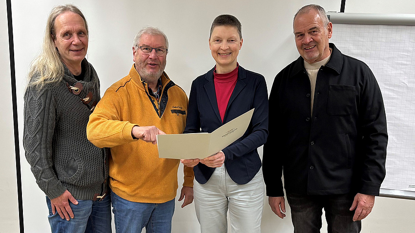 Marion Götz übergibt den Förderbescheid an Harald Steiper, Lars Corsmeyer und Klaus Ledderhose.